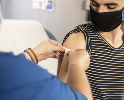 Doctor putting band-aid on patient's arm